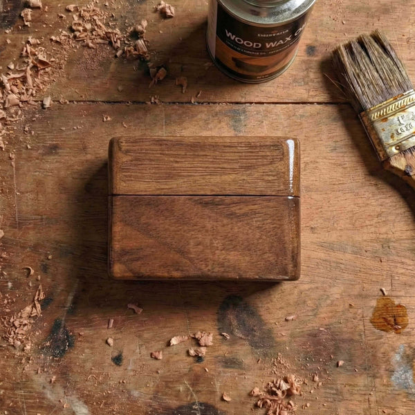 Rectangular wooden guitar pick holder with a magnetic detachable lid, showcasing dark walnut texture and compact design for pockets.