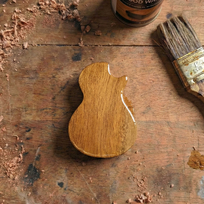 Pocket-sized wooden pick box shaped single cutaway design without neck, glossy wood finish.