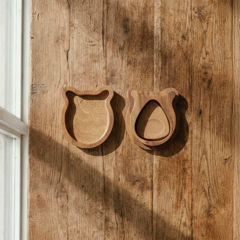Top view of a cute bear-shaped wooden guitar pick box, open to show a single recessed pick slot, resting on a rustic wood surface. Perfect gift for guitarists.