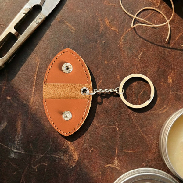 Vegan leather guitar pick holder keychain with snap button closure, shown open.