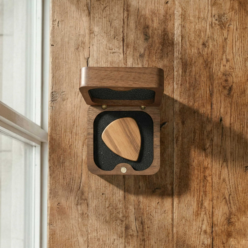 Compact square wooden pick box with rounded corners. Features a premium black foam insert holding a single wooden pick, with a magnetic hinged lid.