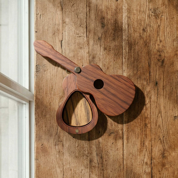 Wooden pick case shaped like a ukulele or mini guitar body. Features a pivoting swivel lid and a single recessed slot for a guitar pick.