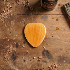 Guitar pick shaped wooden box, light wood color with vertical grain, distinct glossy finish for storing guitar picks.