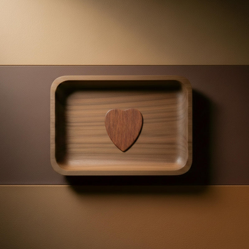 Heart-shaped rosewood guitar pick displayed in a wooden tray.