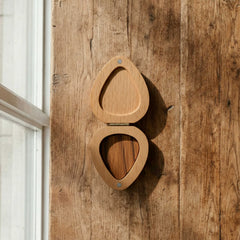 Teardrop-shaped wooden pick box matching the silhouette of a standard guitar pick. Open with a hinged lid, showcasing high-quality wood craftsmanship.