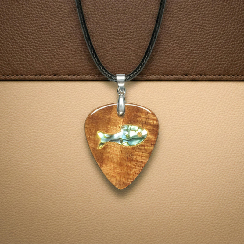 Handmade wooden guitar pick pendant featuring an iridescent abalone shell fish inlay on a leather cord.